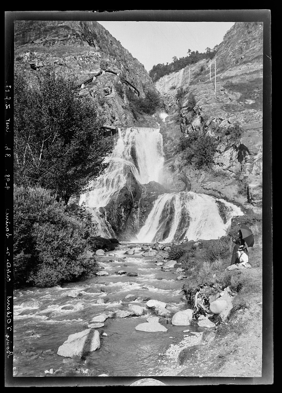 Photo ancienne (noir et blanc, format portrait, 2412x3352, 1,3 Mo) de la chute de la Sarenne, prise entre 1890 et 1914. Page Commons : https://commons.wikimedia