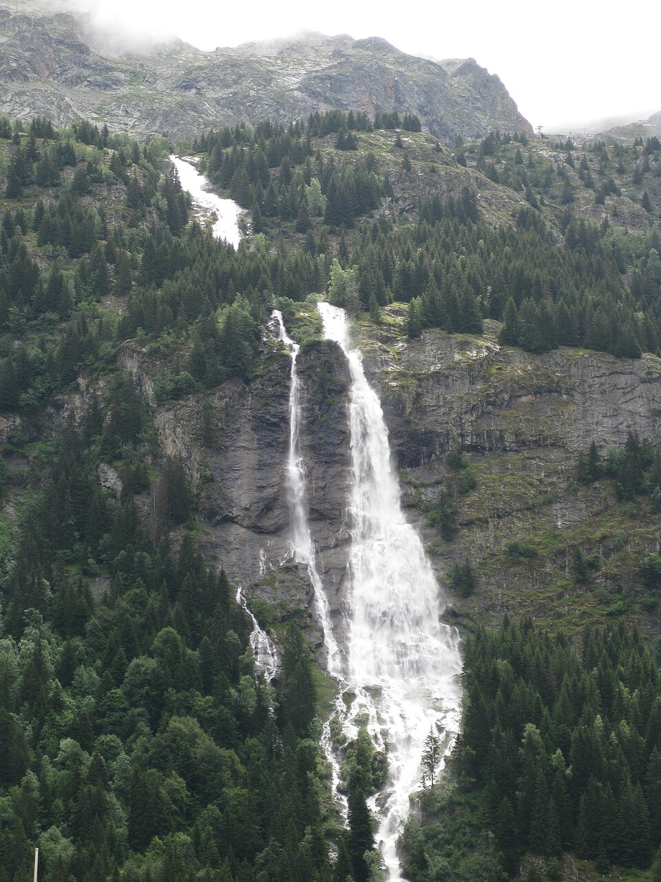 La cascade de la Fare vue depuis Vaujany, la paroi que suit la via ferrata (portrait 2736x3648, prise en 2011, mise en ligne en 2014) ; page : https://commons.w