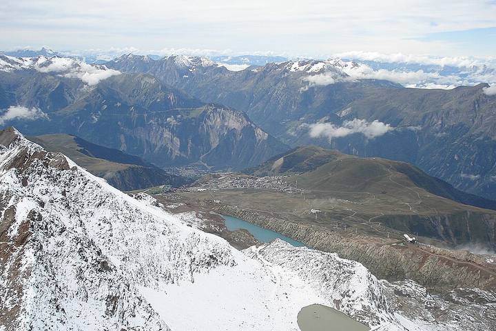 Vue du Pic Blanc sur l'Alpe d'Huez et la plaine du Bourg-d'Oisans : le trajet du Grand vol. Paysage 1600x1064, licence vérifiée via l'API Commons le 18/10/2026.
