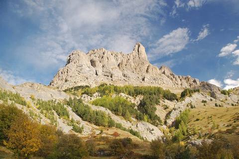 Parois rocheuses claires et mélèzes dorés en automne, vus depuis la route du col d'Ornon