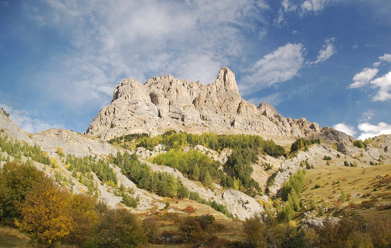 Parois rocheuses claires et mélèzes dorés en automne, vus depuis la route du col d'Ornon