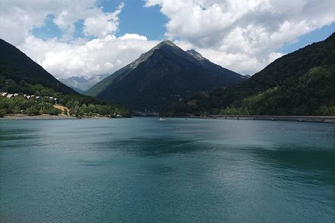 Le lac du Verney aux eaux turquoise vu depuis le barrage, avec à droite le viaduc de la D526 qui longe le lac